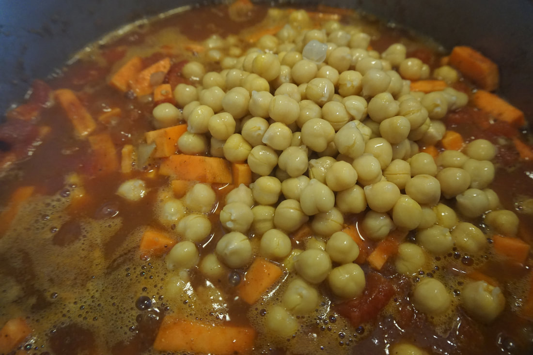 Close up view of canned chickpeas sitting on top of the stew 