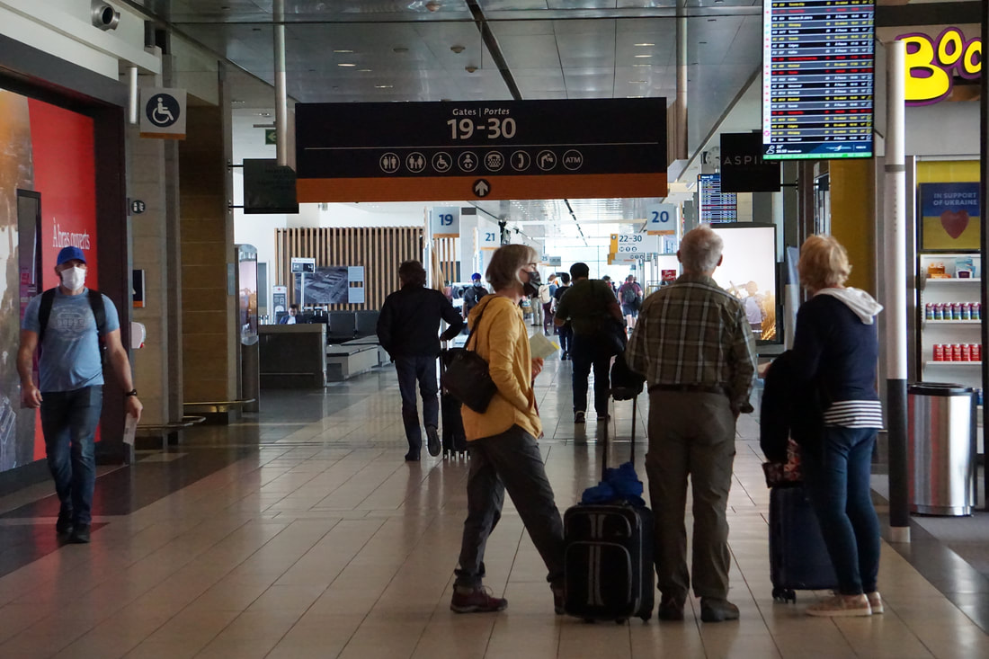Various people walk through a concourse in Ottawa's airport.