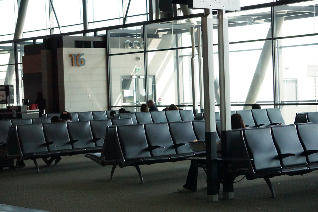Rows of empty black seats in an airport terminal