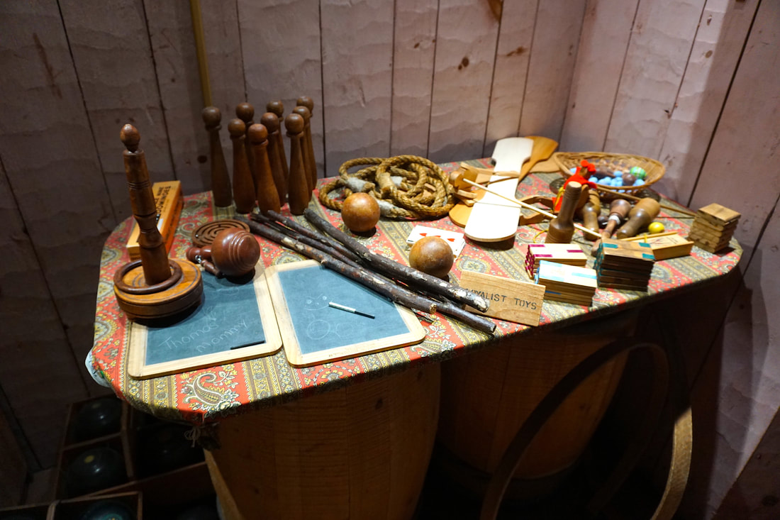 Assorted wooden items sit on a table with a small sign that says 