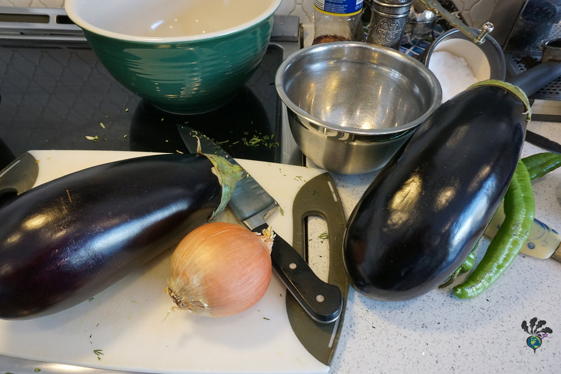 Eggplants on the counter with cutting board, knife, and bowlsPicture