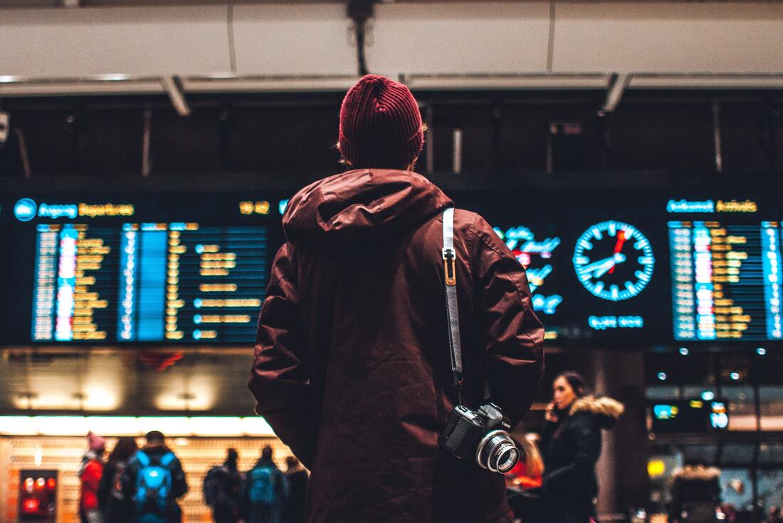 Canadian Transportation Agency Flight Delay Compensation Rules. A backpacker stares a flight information board in an airport