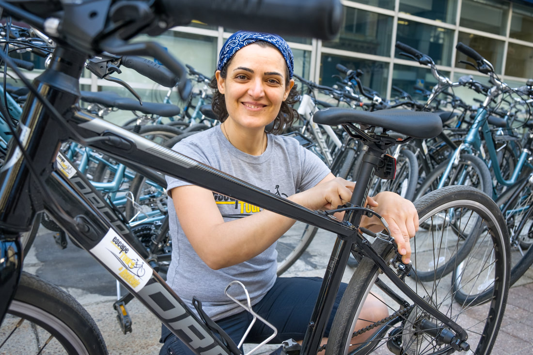 Maria crouches among dozens of bikes with dark frames Picture
