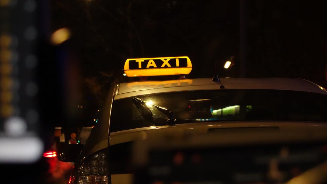 Taxi cab in the dark, only the taxi sign is illuminated
