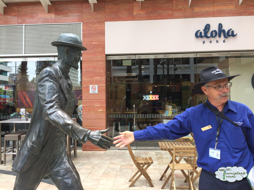 Free walking tours with iCity in Perth Australia: Tour guide poses with a statue. 