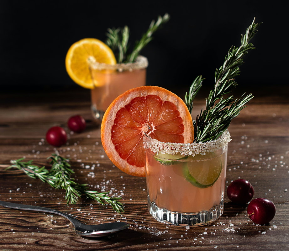 short cocktail glass filled with pink liquid and topped with rosemary and a grapefruit wheel