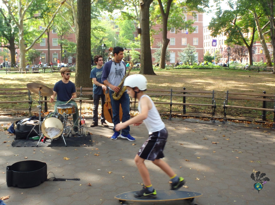 Greenwich Village Food Tour New York: A band busks in Washington Square Park while a kid on a skateboard goes by