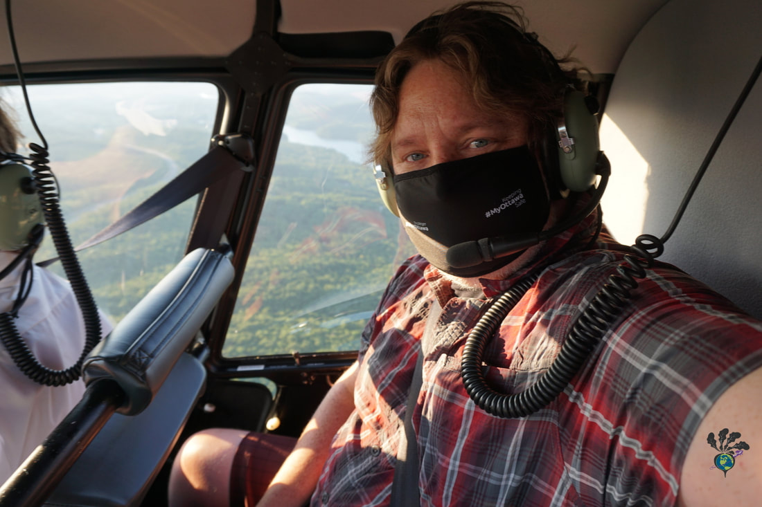 Selfie of Ryan wearing a red plaid shirt in the Heli Tremblant Helicopter's back seat