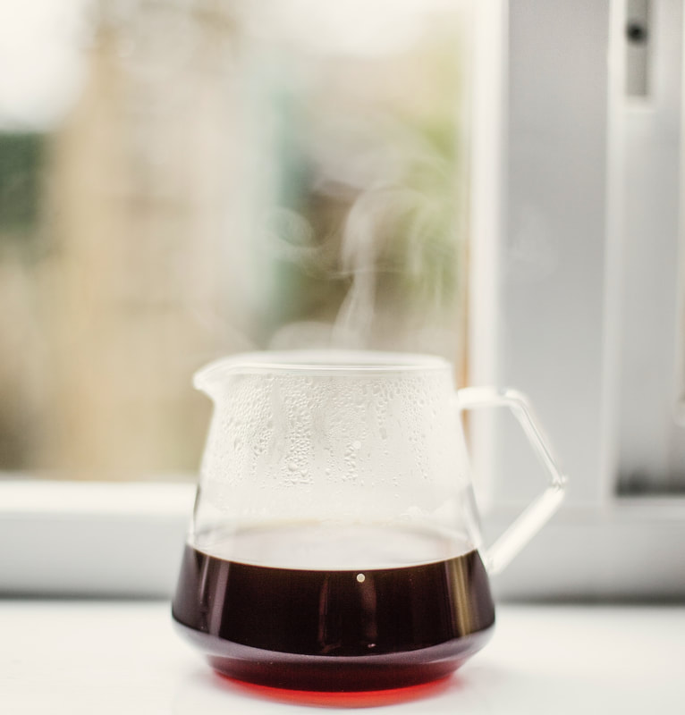 Glass carafe filled part way with coffee Picture