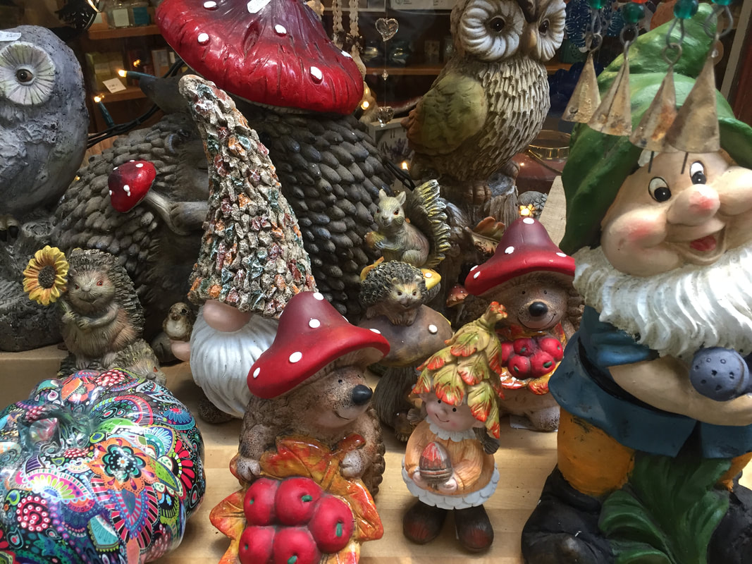 Garden centre display of gnomes and woodland creatures made from wood.