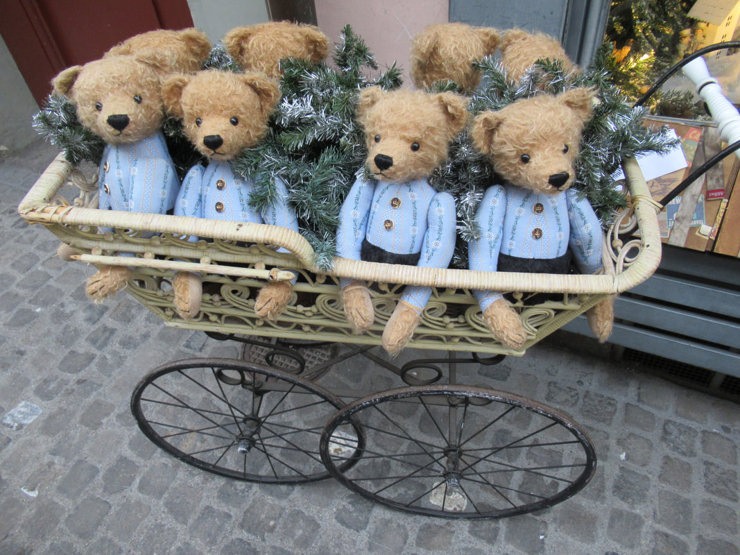 Traveling with teddy bears: Four old fashioned bears in blue suits sit in a basket