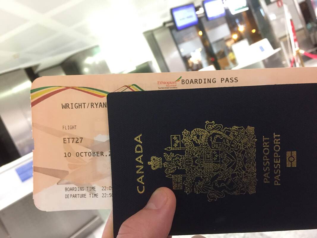Ryan holds his passport and a boarding pass for Ethiopian Air