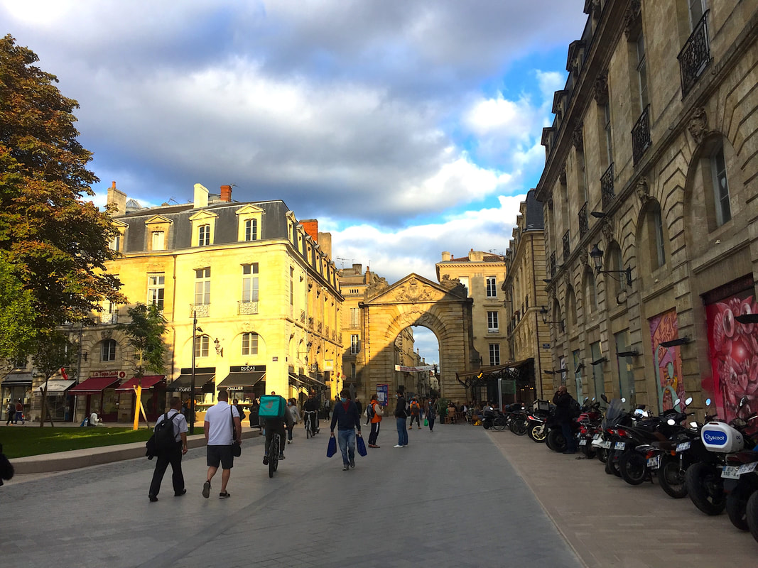 Two days in Bordeaux: Street scene at dusk at a city gate.