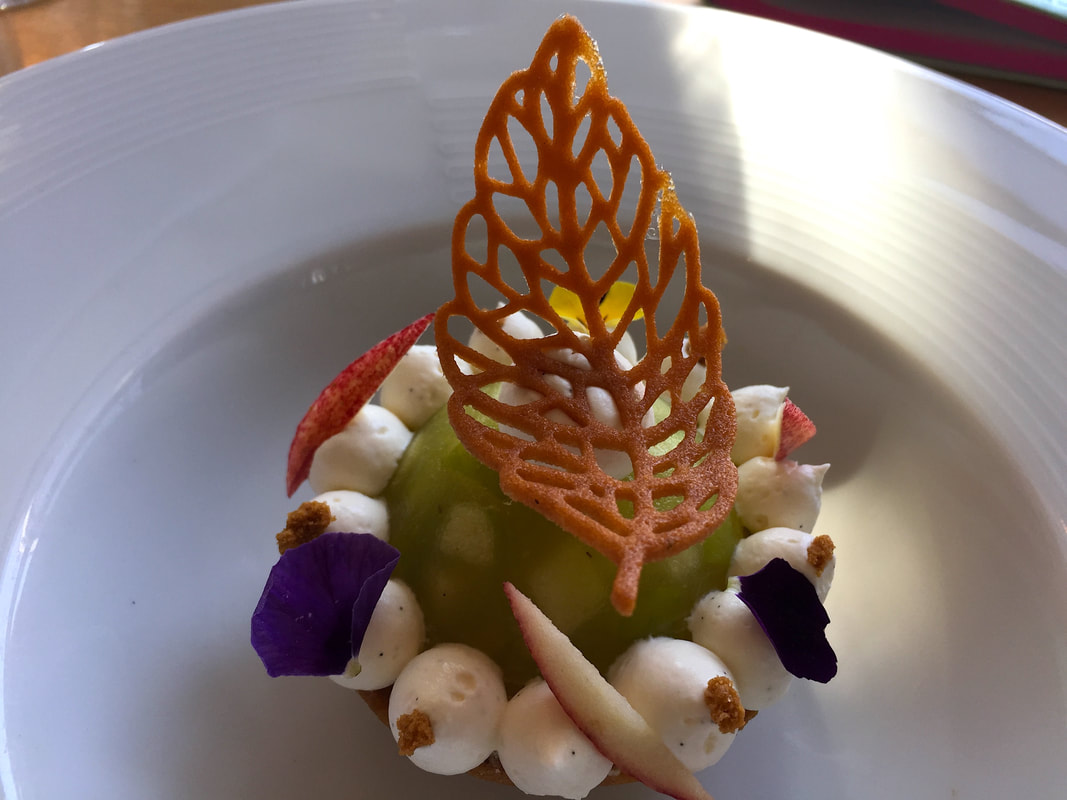 Green pear ice cream decorated with puffs of meringue and twill cookies in the shape of leaves