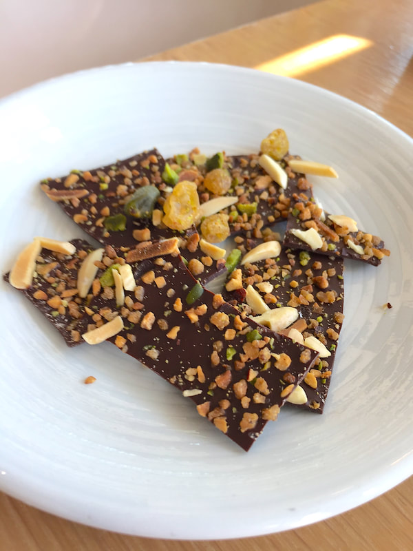 Pieces of dark chocolate park studded with nuts and dried fruits.