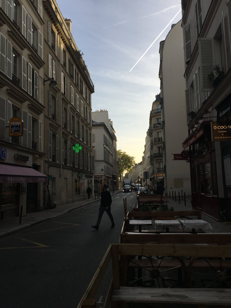 Sidewalk tables set up in the early morning on a typical Parisian street