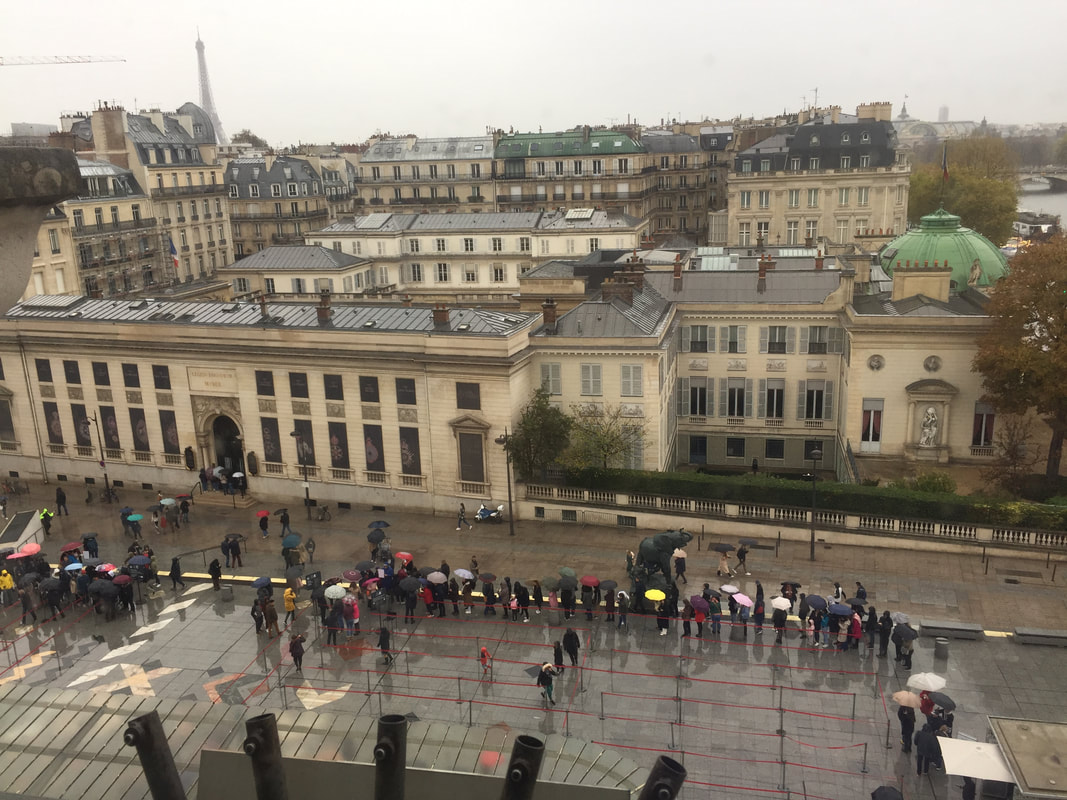 Aerial view of people waiting in line in the rain at the Musee D'Orsay