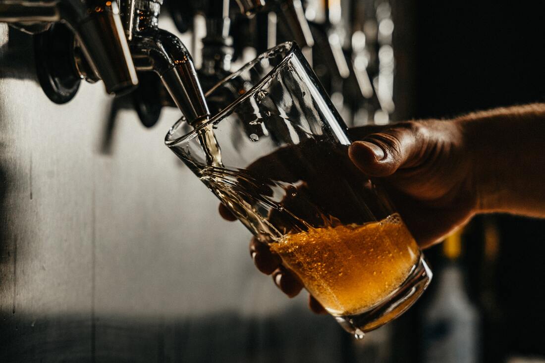 Dark photos showing beer being poured from a tap.