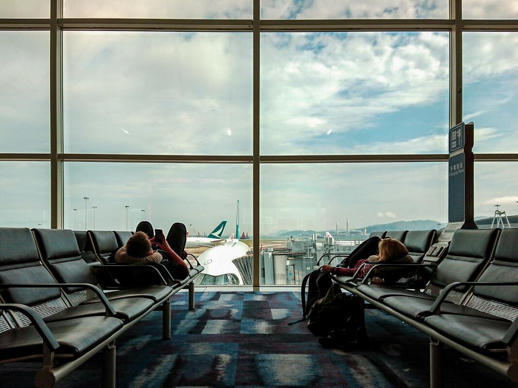 Canadian Transportation Agency Flight Delay Compensation Rules. Two passengers sleep on seats at the airport