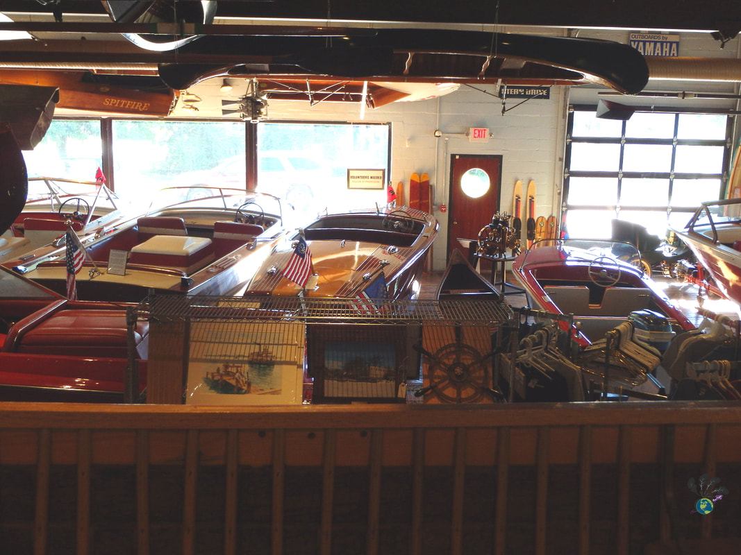 Looking at a collection of vintage motorboats from the balcony of the Lawson Boat Center Museum 