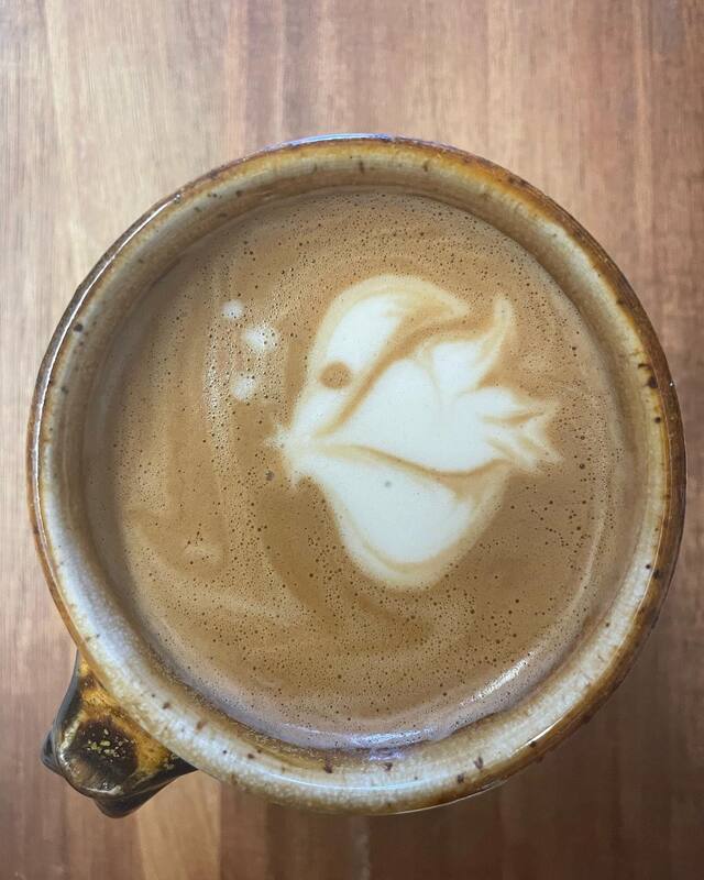 A pottery cafe cup showing an angle fish drawn in the latte foam