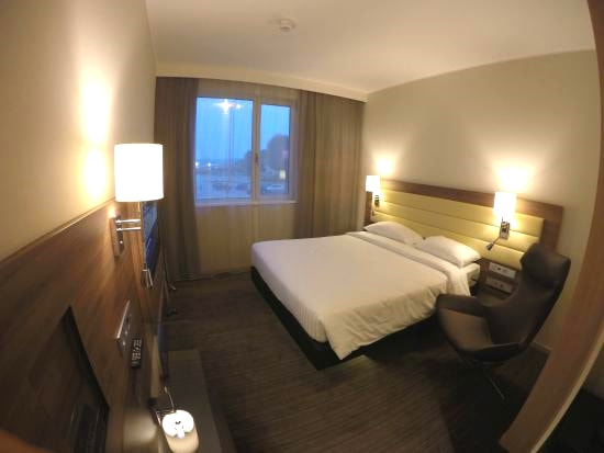 Moxy Milan Malpensa Airport Hotel bedroom with white bed and tv on wallPicture