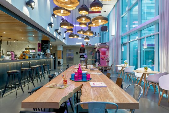 Moxy Milan Malpensa Airport Hotel lobby with bar and tablesPicture