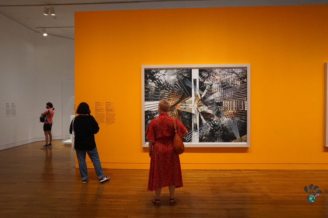 Three patrons at the National Gallery of Canada examine modern prints on a bright orange wall ure