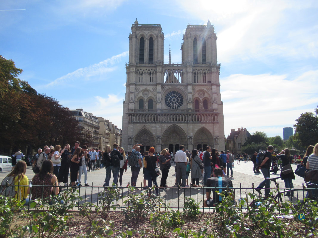 Crowds line up outside Notre Dame on a sunny day in Paris Picture