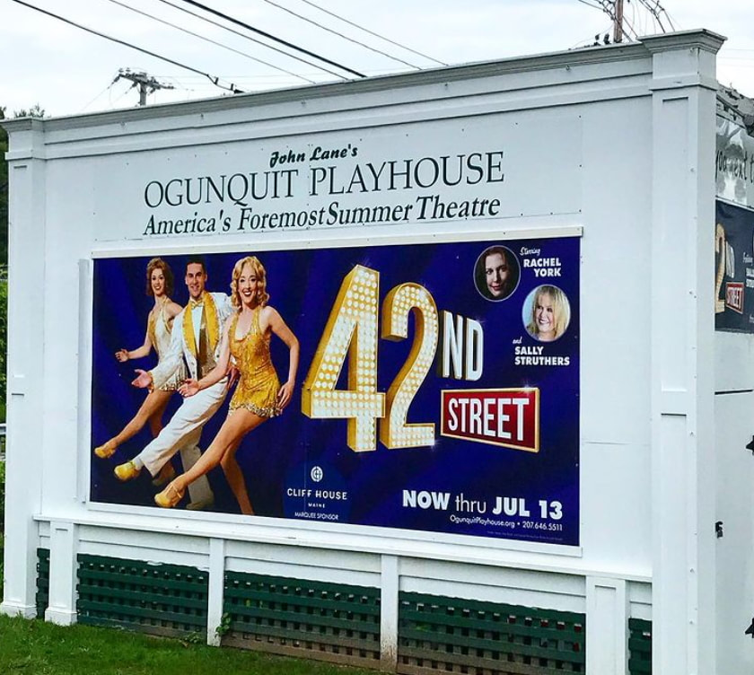 Large white sign advertising upcoming productions outside the Ogunquit Playhouse Picture