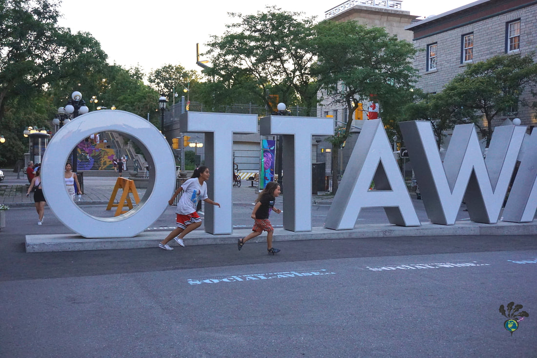 Children running in front of the Ottawa sign in the Byward MarketPicture