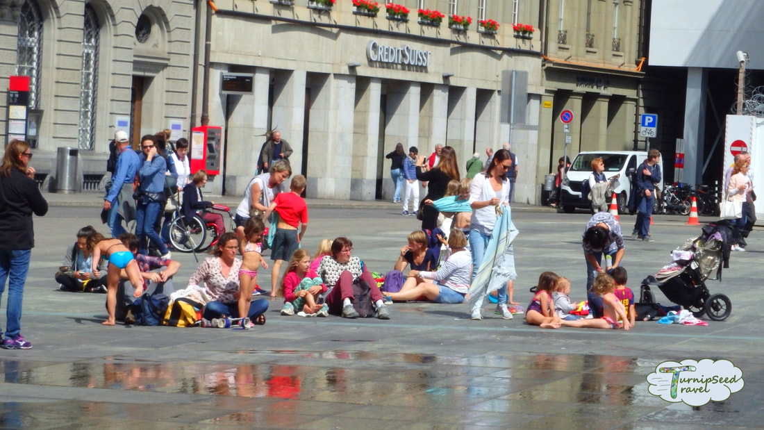 People hangout at a public square that will transform into a fountain