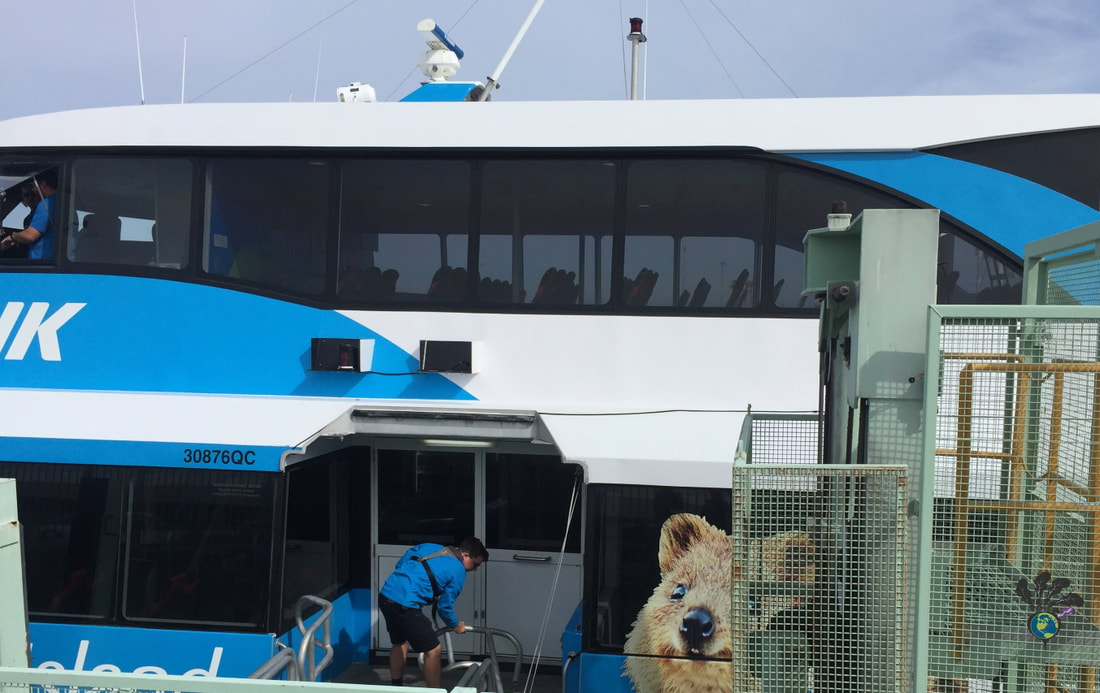 Staff open the walkway gate on a blue and white ferry with grey tinted windows Picture