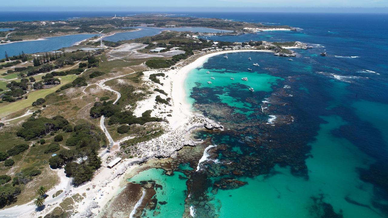 Aerial view of island land, shrubs, ocean water and reefs: Flights to Rottnest Picture