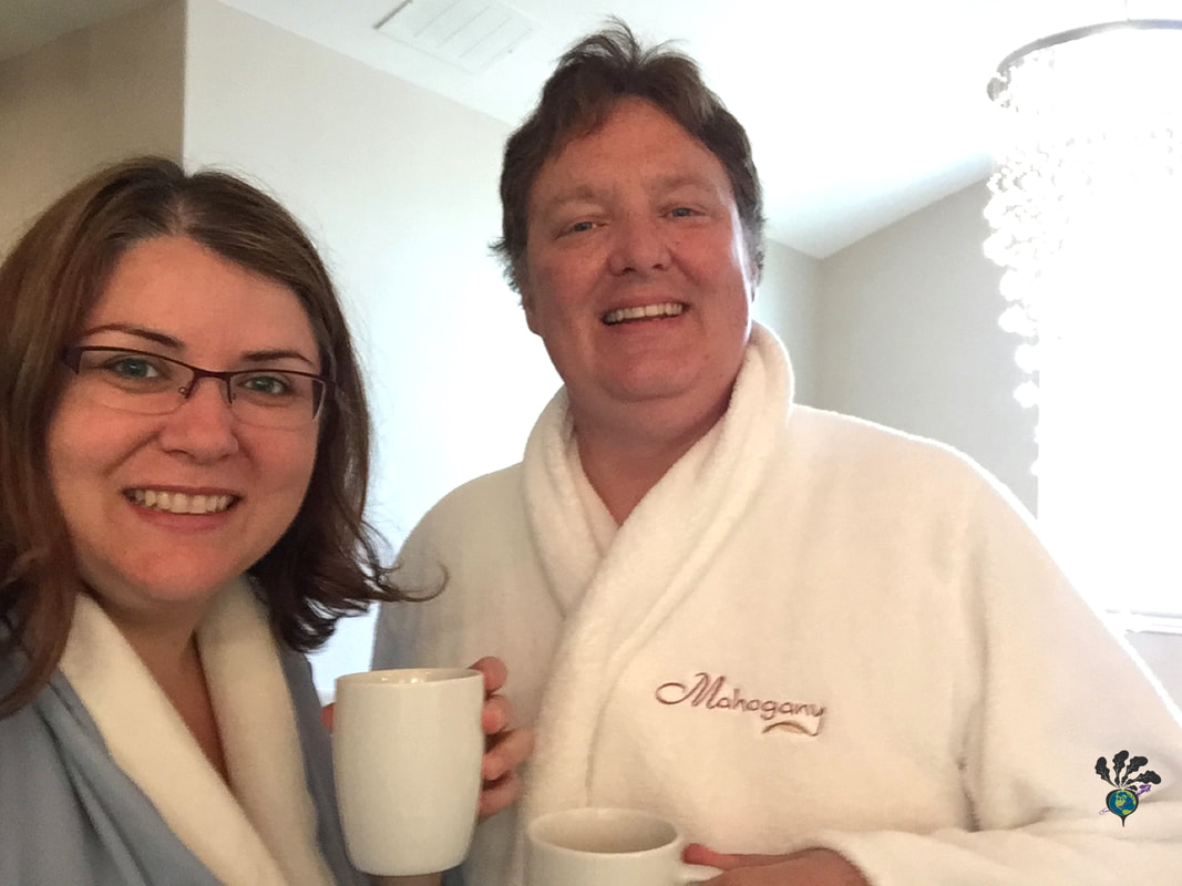 Ryan and Vanessa in bathrobes at a spa, holding coffee mugsPicture