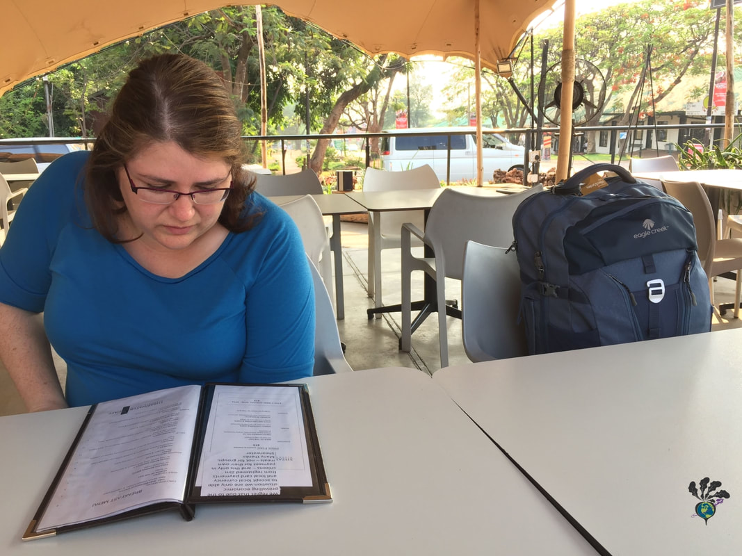 Shearwater Cafe Victoria Falls outdoor veranda Vanessa studies the menu