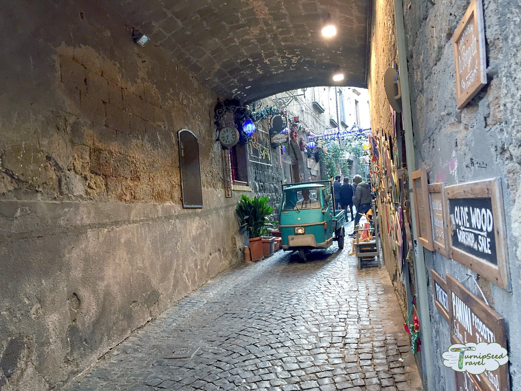 Shops down a cobblestone alleyway in Orvieto by TurnipseedTravel