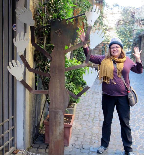Vanessa poses with a sculpture of hands in Orvieto 