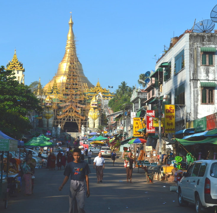The golden Swedagon Pagoda in Yangon, Myanmar, along with a busy street Picture