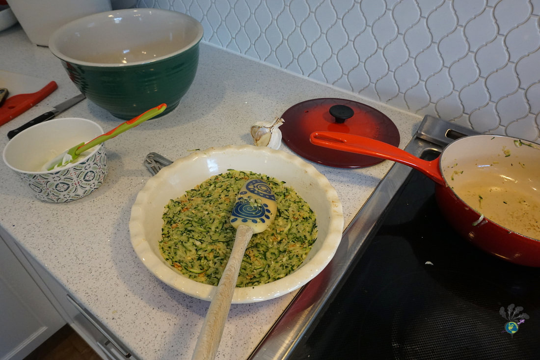 Prepared zucchini dish on the counter with different bowls and pans aroundPicture