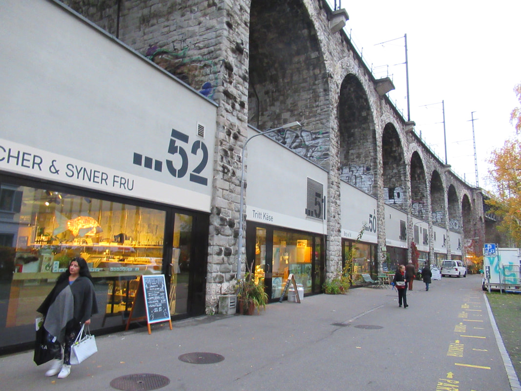 Outside the shops of the viaduct, each separated with grey stone arches